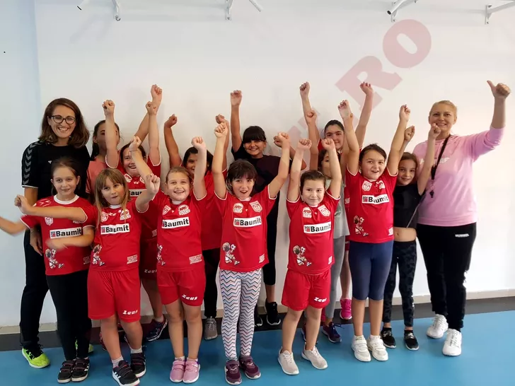Copii din grupa de mini handbal alături de antrenoarele Daniela Strat (în stânga) și Clara Geamănu (dreapta)