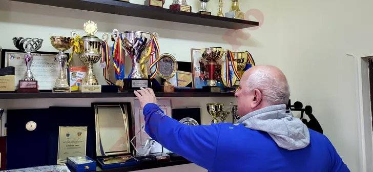 Gheorghe Tadici şi peretele din biroul său, plin de trofee. Sursa: Fanatik