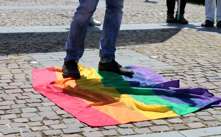 Simpatizanții Noua Dreaptă, stând pe un steag LGBT la mitingul din Cluj-Napoca *foto: Ziua de Cluj