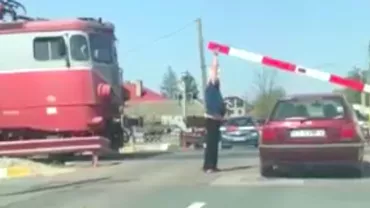 Scene ireale in Romania Conductorul unui tren nevoit sa coboare ca sa ridice bariera de pe o masina